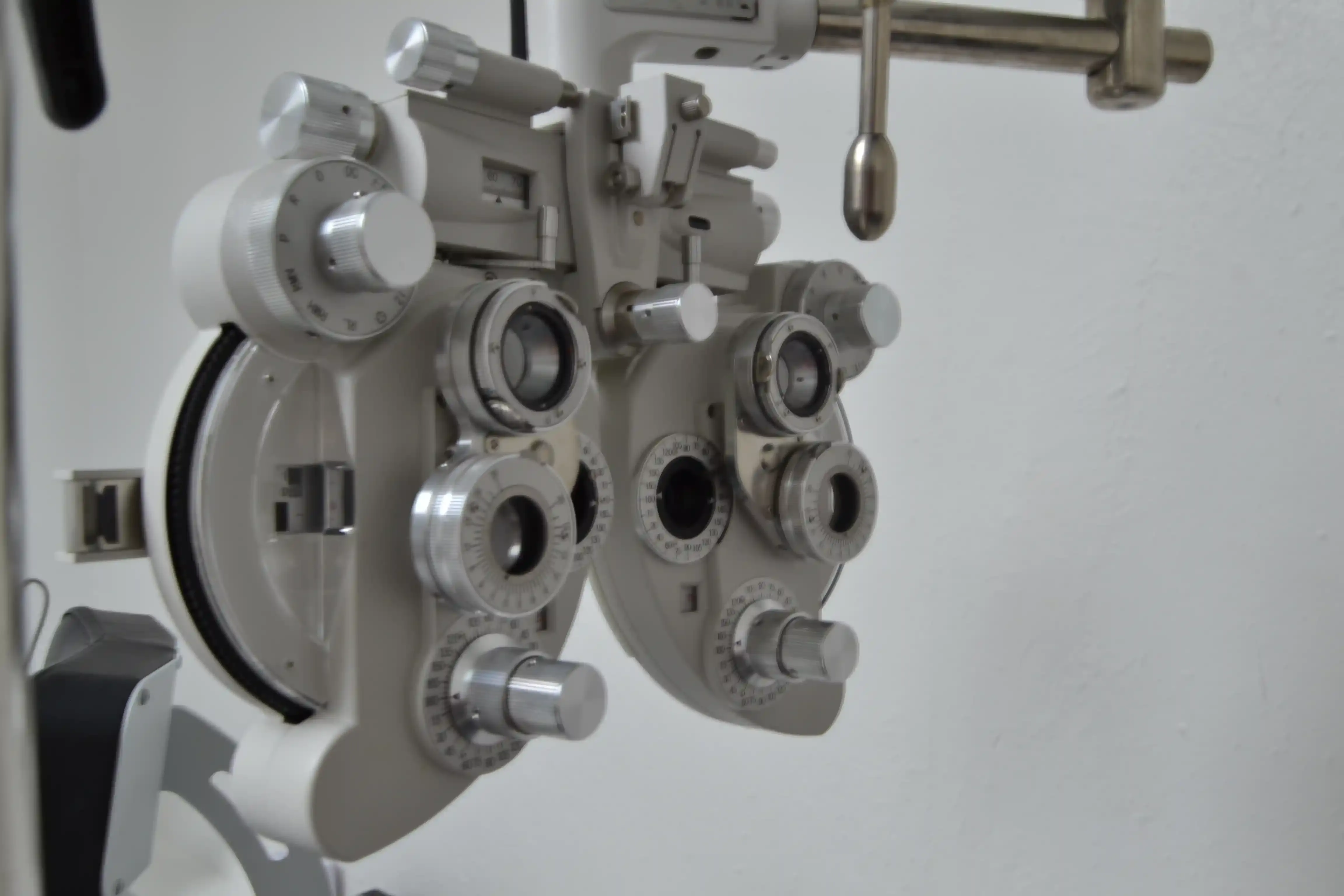 Niña sonriente mientras una oftalmóloga pediatra le realiza un examen de la vista en un consultorio amigable para niños.